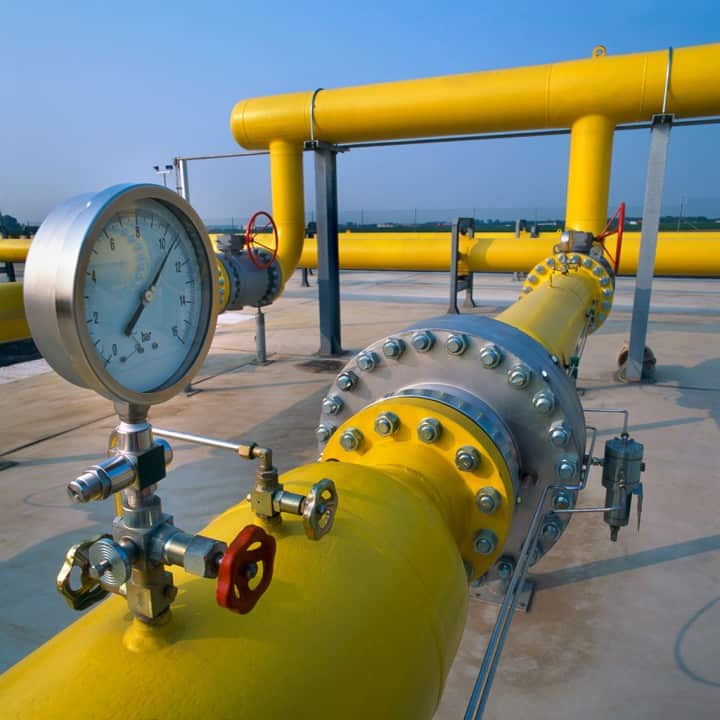 yellow pipeline demonstrating hydraulic leak testing with a pressure gauge presented above the piping