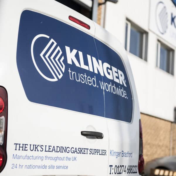 KLINGER UK van with trusted.worldwide. logo displayed on it. In the distance stands the Bradford headquarters with the KLINGER United Kingdom logo blurred out.