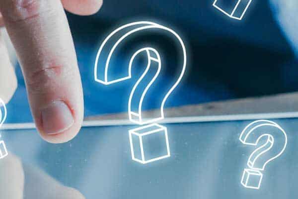 Finger touching a mobile device with question marks surrounding it